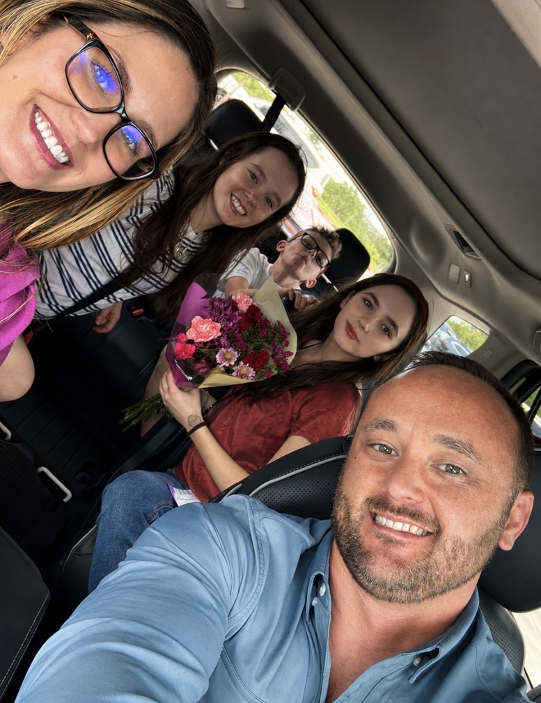 A family selfie with Kyle, his wife Amber, and their three children together in the car
